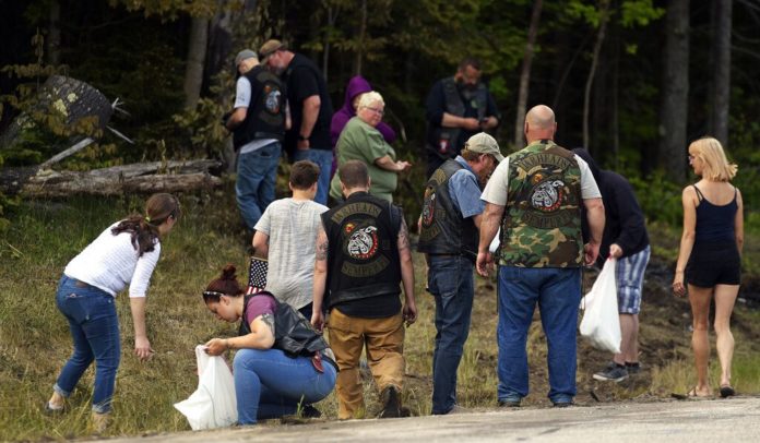 People recover personal items from the scene of a fatal accident on Route 2 in